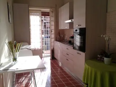 a kitchen with white cabinets and a table in it at B&B Di Leo in Rome