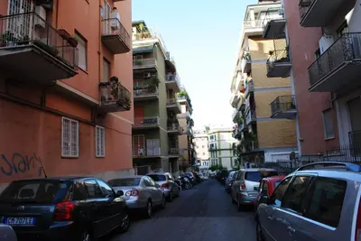 a street with cars parked on the sides of buildings at B&B Di Leo in Rome