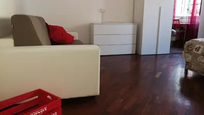 a living room with a white couch and a dresser at DaMa Domus in Rome