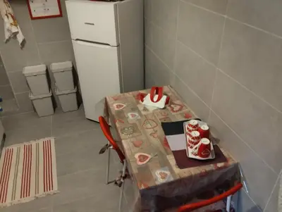 a small kitchen with a table and a refrigerator at DaMa Domus in Rome