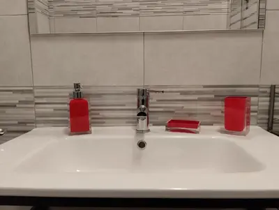 a bathroom sink with two faucets and two red containers at DaMa Domus in Rome