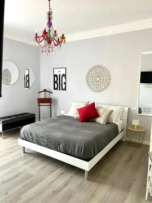 a bedroom with a large bed and a chandelier at Matilda House Trastevere 8 posti letto in Rome