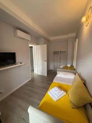 a bedroom with a yellow bed and a tv at Matilda House Trastevere 8 posti letto in Rome