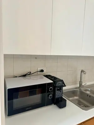 a microwave sitting on a kitchen counter next to a sink at La Maison di Trastevere in Rome