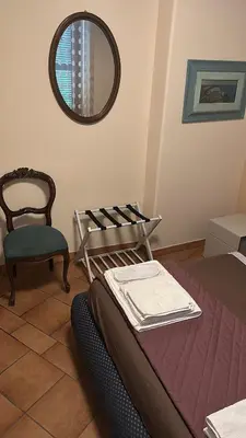a room with a bed and a chair and a mirror at La Maison di Trastevere in Rome