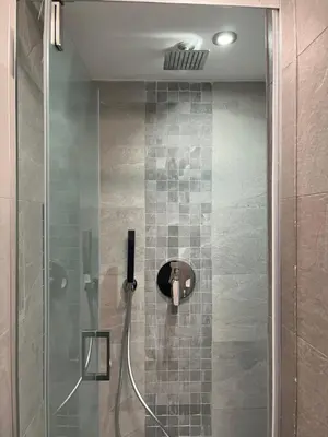a shower with a glass door with a shower head at Studio flat ultimo piano in centro in Rome