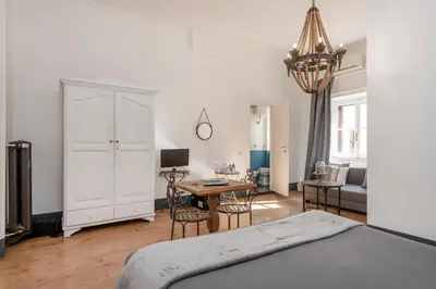 a bedroom with a bed and a desk and a table at Angelina Dimora Contemporanea in Rome