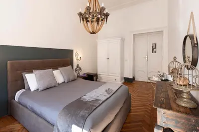 a bedroom with a large bed and a chandelier at Angelina Dimora Contemporanea in Rome