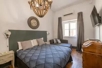 a bedroom with a bed and a television and a chandelier at Angelina Dimora Contemporanea in Rome