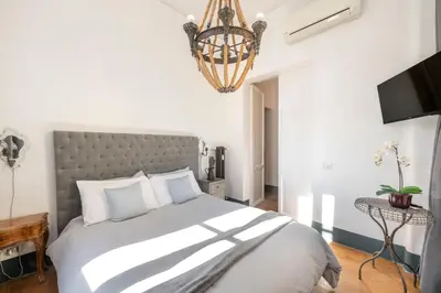 a bedroom with a large bed and a chandelier at Angelina Dimora Contemporanea in Rome