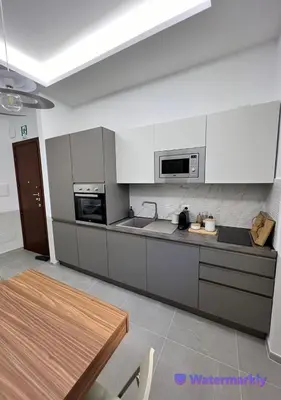 a kitchen with white appliances and a wooden table at ITALIANAS Vatican in Rome