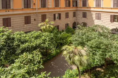 a building with a bunch of trees in front of it at AD MAIORA SUITE in Rome