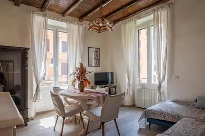 a dining room with a table and chairs and a bedroom at AD MAIORA SUITE in Rome
