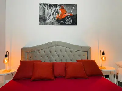 a bedroom with a bed with red pillows and a motorcycle at Vatican Inside House in Rome