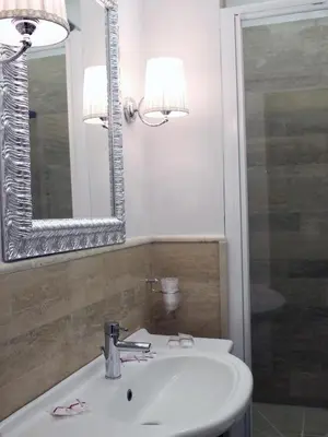 a bathroom with a sink and a mirror at Piccolo di Piazza di Spagna Suites in Rome