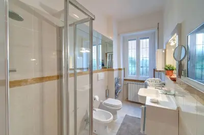 a bathroom with a toilet and a sink and a shower at Viale Tirreno - Appartamento con Patio in Rome