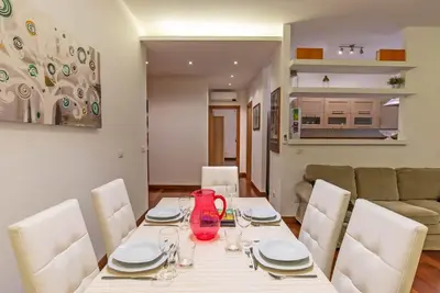 a dining room with a white table and white chairs at Viale Tirreno - Appartamento con Patio in Rome