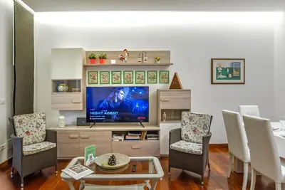 a living room with a tv and a table and chairs at Viale Tirreno - Appartamento con Patio in Rome