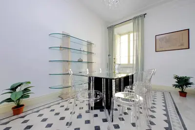 a dining room with a glass table and chairs at Divine Vatican View Apartment in Rome