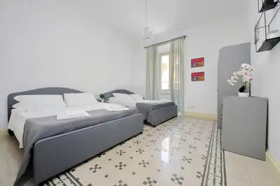 a bedroom with two beds and a rug at Divine Vatican View Apartment in Rome