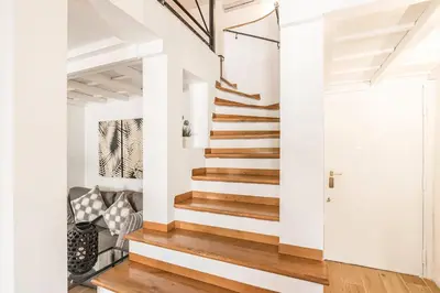 a staircase in a home with white walls and wood floors at Thebestinrome Orbitelli in Rome