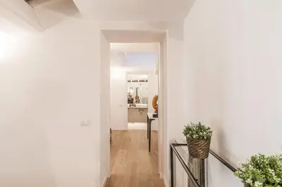 a hallway with white walls and a vase on a railing at Thebestinrome Orbitelli in Rome
