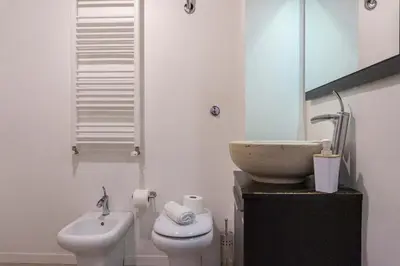 a white bathroom with a sink and a toilet at EasyTopStay - Castel Sant'Angelo Cosy Flat in Rome