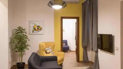 a living room with two chairs and a tv at Saint Peter Prestigious by Rental in Rome in Rome