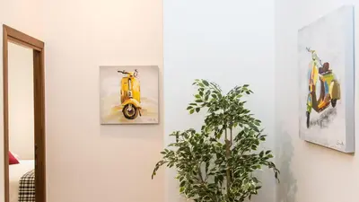 a yellow scooter on a wall next to a plant at Saint Peter Prestigious by Rental in Rome in Rome