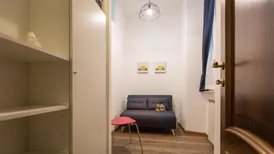 a hallway with a blue chair and a pink stool at Saint Peter Prestigious by Rental in Rome in Rome