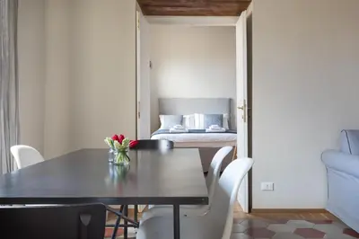 a dining room with a table and chairs and a bed at Mami's Home Trastevere apt with private terrace in Rome