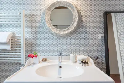 a bathroom with a white sink and a mirror at Mami's Home Trastevere apt with private terrace in Rome
