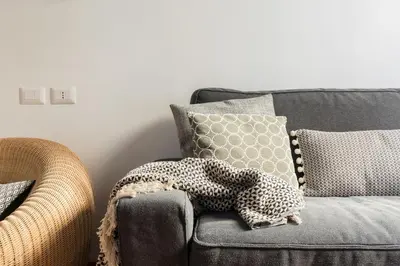 a gray couch with pillows and a blanket on it at Mami's Home Monti in Rome