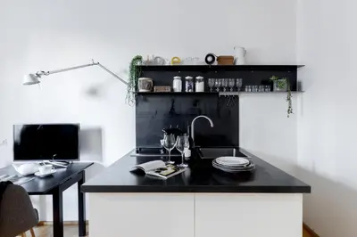 a black kitchen with a sink and a desk at Mami's Home Monti in Rome