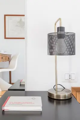 a desk with a book and a lamp on it at Mami's Home Monti in Rome
