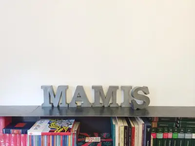 a shelf with a sign on top of books at Mami's Home Monti in Rome