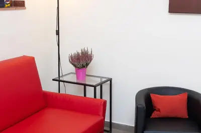 a room with two chairs and a table with a red couch at Principe Amedeo By Rental in Rome in Rome
