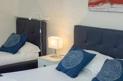 a bedroom with two beds with blue pillows and a lamp at Principe Amedeo By Rental in Rome in Rome