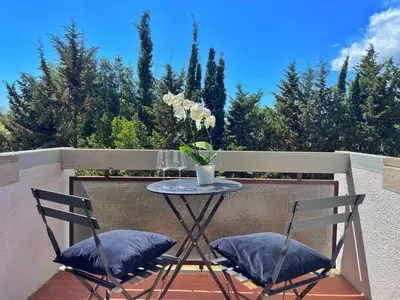 a table with two chairs and a vase of flowers on a balcony at L' oasi di Roma - Modern apartment with pool&parking in Rome