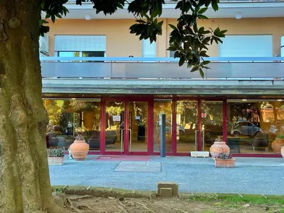a building with large glass doors with vases in front of it at L' oasi di Roma - Modern apartment with pool&parking in Rome