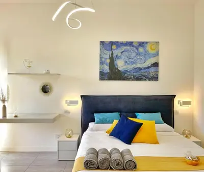 a bedroom with a bed with blue and yellow pillows at L' oasi di Roma - Modern apartment with pool&parking in Rome