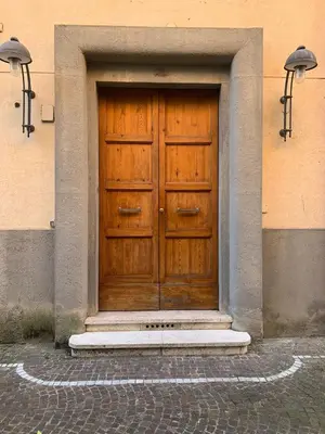 a wooden door on a building with two lights at La Divina Duse in Rome