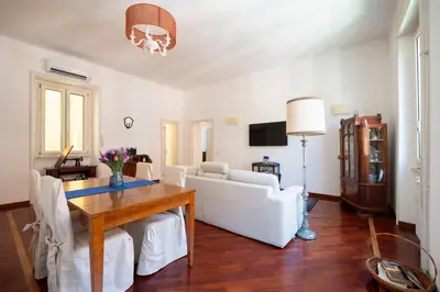 a living room with a table and a white couch at La Divina Duse in Rome