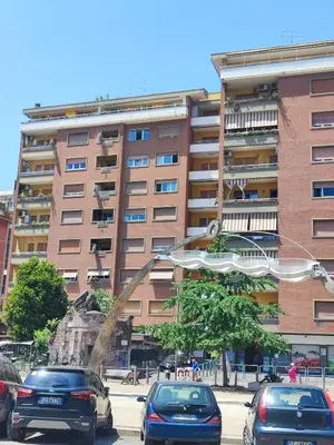 a large building with cars parked in front of it at Trilogy in Trastevere in Rome