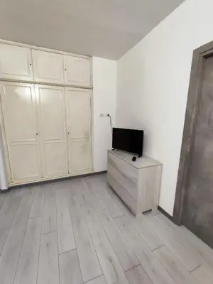 a white room with a tv on a wooden dresser at Trilogy in Trastevere in Rome