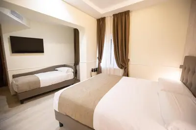 a hotel room with two beds and a television at Hotel Maximus in Rome