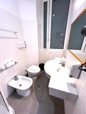 a white bathroom with two sinks and a toilet at Booking Inn Settembre 95 in Rome