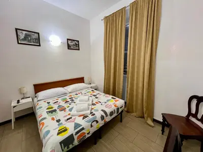 a bedroom with a bed and a desk and a window at Booking Inn Settembre 95 in Rome