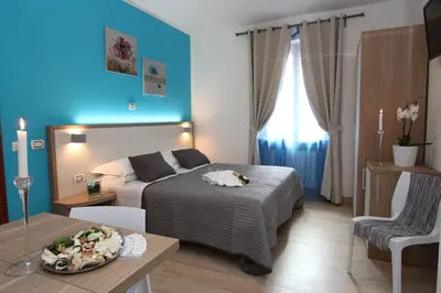 a bedroom with two beds and a table and a couch at La Casa Felice a San Pietro in Rome