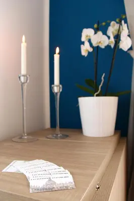 a table with two candles and a vase with white flowers at La Casa Felice a San Pietro in Rome